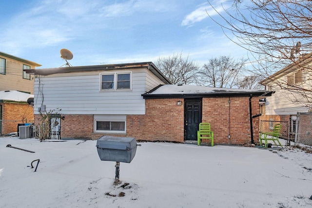 snow covered back of property with central air condition unit