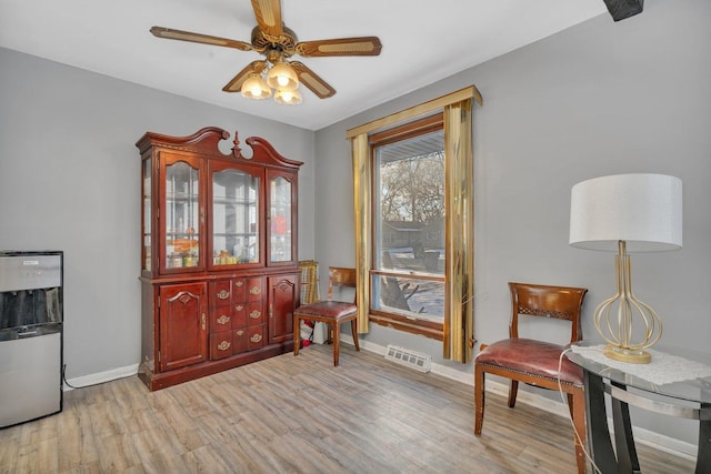 living area with ceiling fan and light wood-type flooring