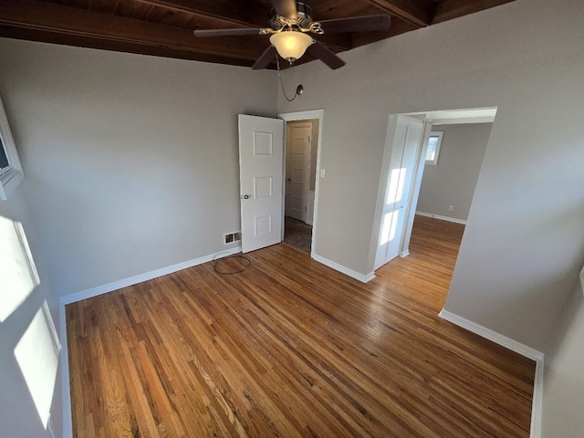 unfurnished room featuring hardwood / wood-style floors, ceiling fan, and beam ceiling