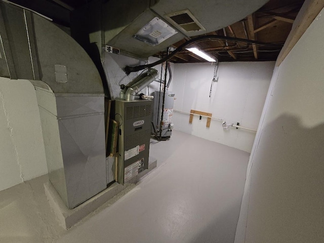 basement featuring gas water heater and heating unit