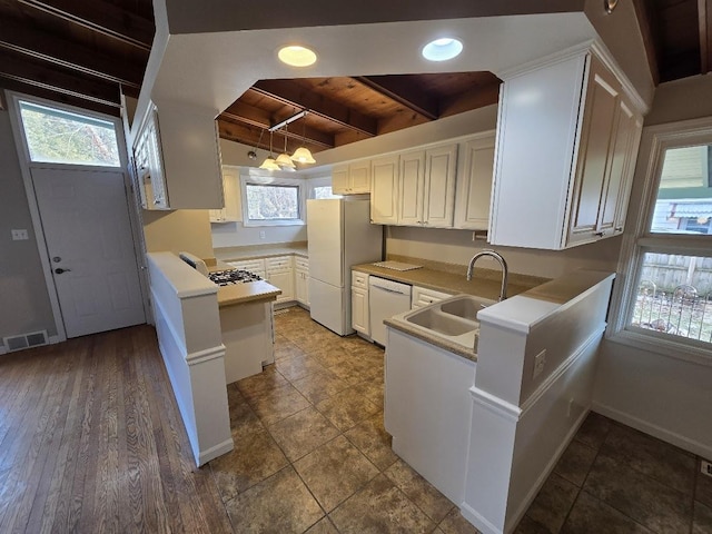 kitchen with white appliances, sink, beam ceiling, white cabinetry, and wood ceiling