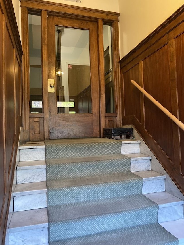 stairway featuring wooden walls