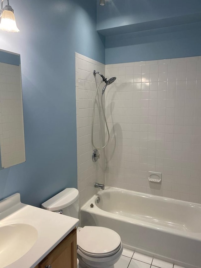 full bathroom featuring toilet, vanity, tile patterned floors, and tiled shower / bath