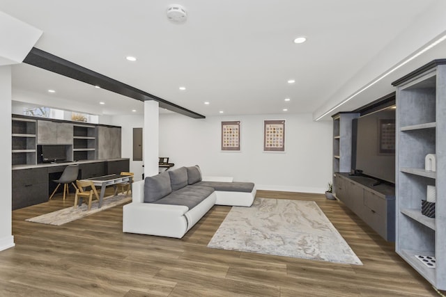 living room with electric panel, built in desk, beamed ceiling, and dark hardwood / wood-style floors