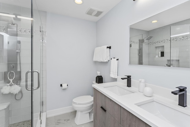 bathroom with toilet, vanity, and a shower with shower door