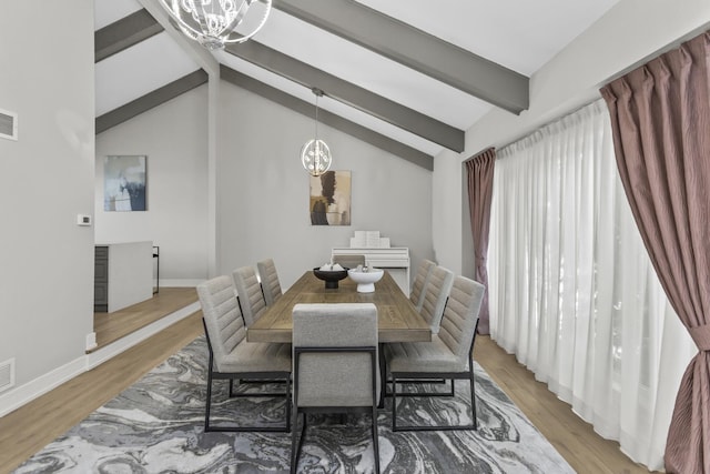 dining space with lofted ceiling with beams, light hardwood / wood-style flooring, and a chandelier