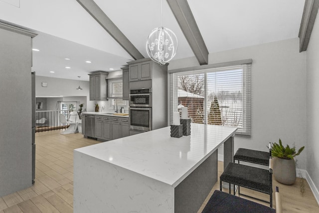 kitchen featuring stainless steel appliances, lofted ceiling with beams, pendant lighting, and gray cabinets