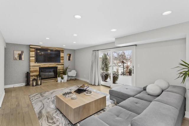 living room with a fireplace and light wood-type flooring