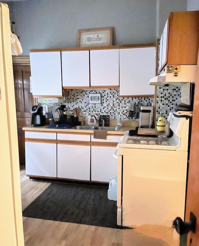 kitchen with white cabinets, decorative backsplash, white appliances, and ventilation hood