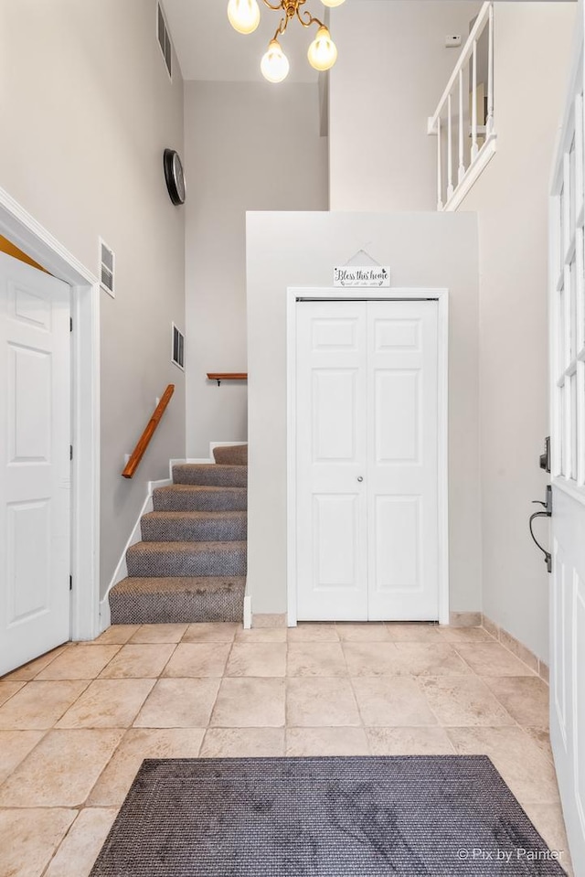 foyer featuring a high ceiling and a notable chandelier