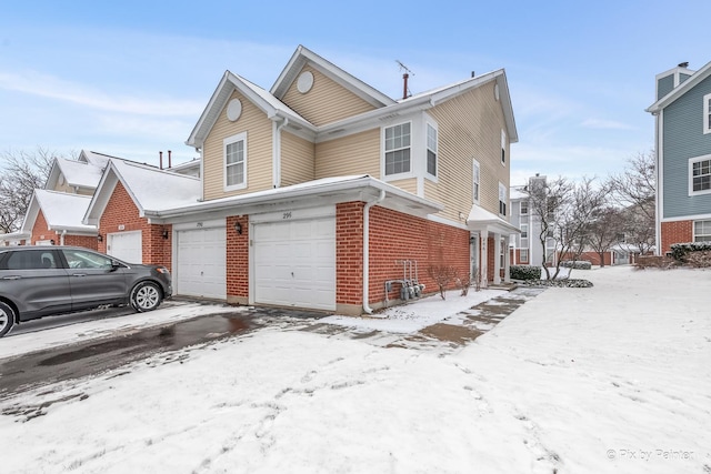 view of snowy exterior featuring a garage