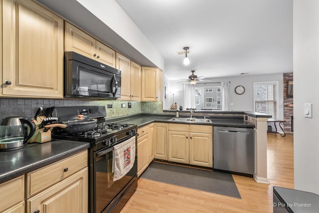 kitchen with kitchen peninsula, black appliances, backsplash, ceiling fan, and sink