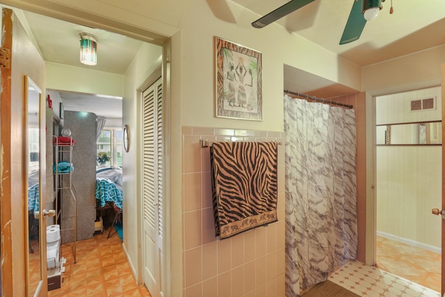 bathroom with ceiling fan, tile walls, and a shower with shower curtain