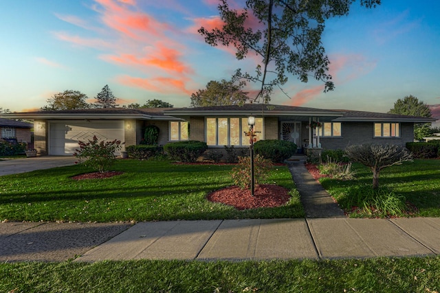 ranch-style home with a garage and a yard