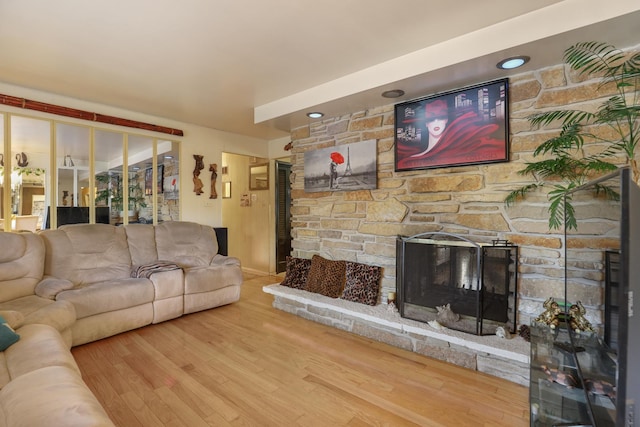 living room featuring hardwood / wood-style flooring and a stone fireplace