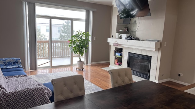 living room featuring hardwood / wood-style flooring and a tiled fireplace