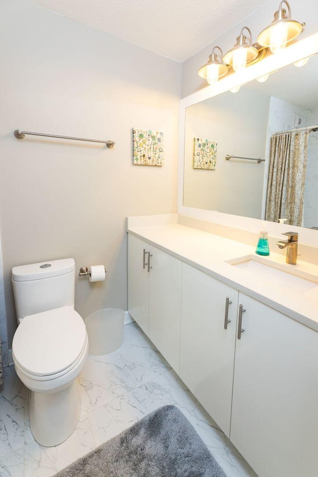 bathroom with a shower with curtain, vanity, and toilet