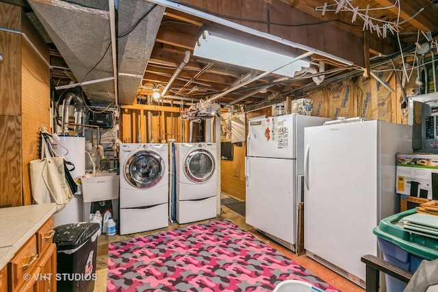 laundry area with gas water heater and independent washer and dryer