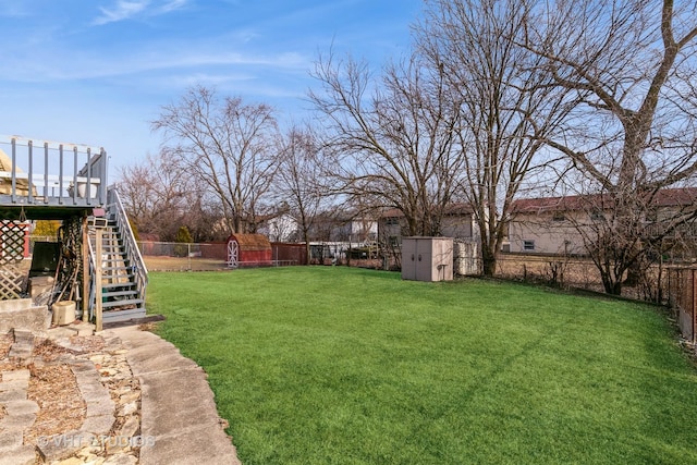 view of yard featuring a storage shed and a wooden deck