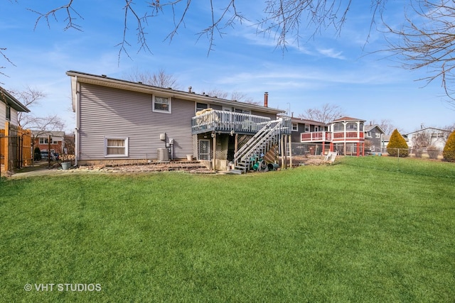 back of house featuring a wooden deck and a lawn