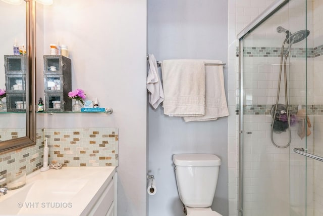 bathroom featuring vanity, an enclosed shower, tasteful backsplash, and toilet