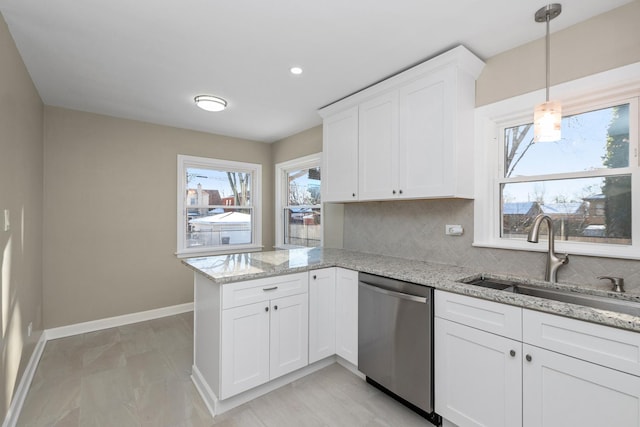 kitchen featuring white cabinetry, sink, backsplash, stainless steel dishwasher, and light stone countertops