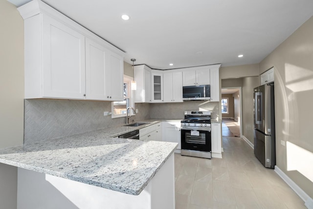 kitchen featuring stainless steel appliances, kitchen peninsula, and white cabinets