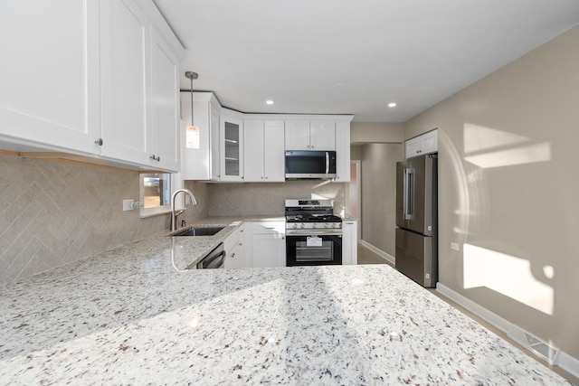 kitchen featuring white cabinets, stainless steel appliances, sink, and backsplash