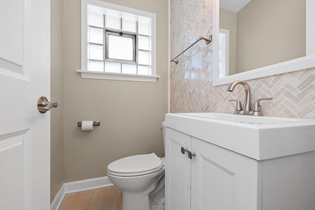 bathroom with vanity, decorative backsplash, wood-type flooring, and toilet