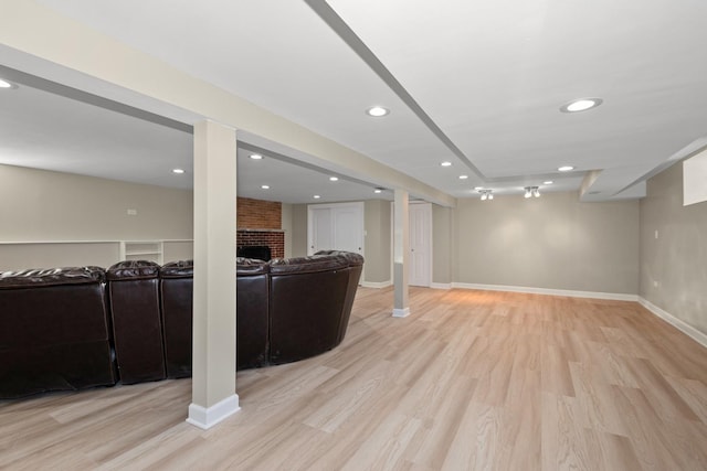 basement with a fireplace and light wood-type flooring