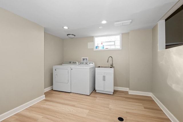 washroom featuring light wood-type flooring, sink, and washer and clothes dryer