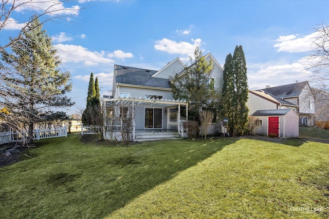 back of property with a yard, a pergola, and a storage unit