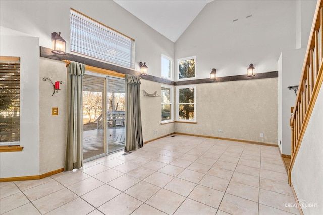 spare room featuring light tile patterned floors and high vaulted ceiling