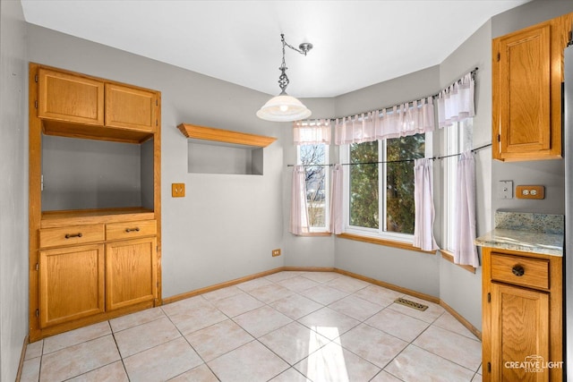 unfurnished dining area featuring light tile patterned flooring