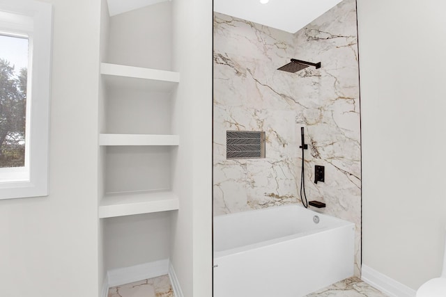 bathroom featuring built in shelves and tiled shower / bath combo