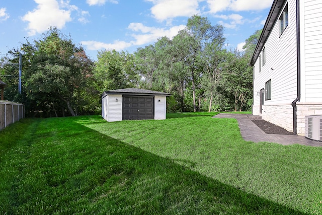 view of yard with a garage, cooling unit, and an outdoor structure