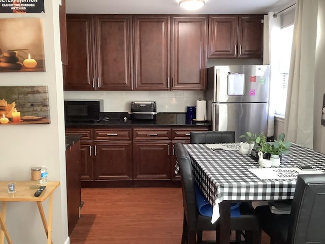 kitchen with wood-type flooring and stainless steel refrigerator