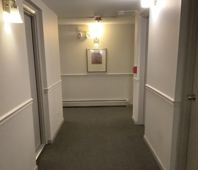 corridor featuring dark colored carpet and a baseboard heating unit