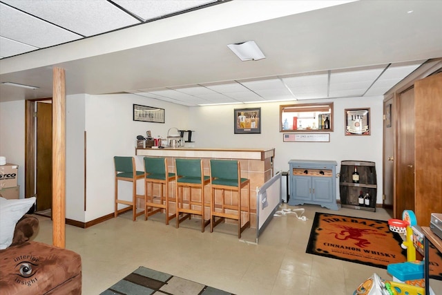 interior space with a drop ceiling and indoor bar