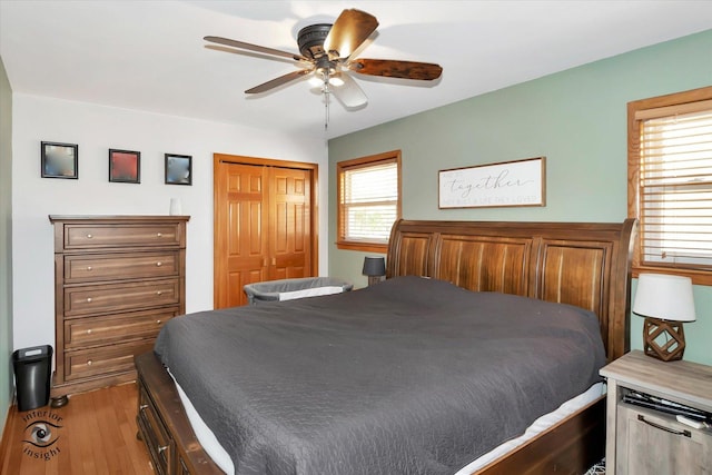 bedroom with ceiling fan, light hardwood / wood-style floors, and a closet