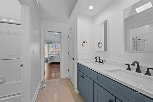 bathroom featuring radiator, vanity, tile patterned floors, and shower / bath combination with glass door