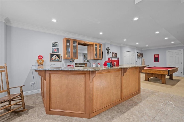 kitchen featuring ornamental molding, billiards, light stone countertops, and a spacious island