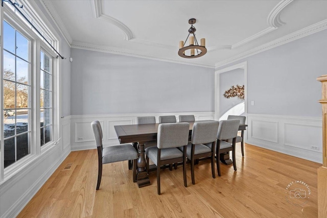 dining room with light wood-type flooring and ornamental molding