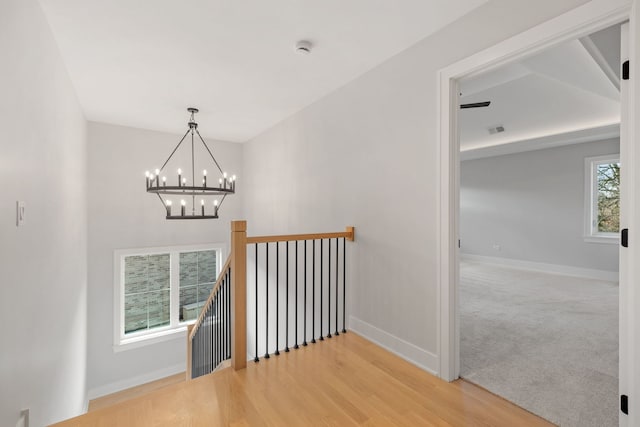 staircase with carpet and a chandelier