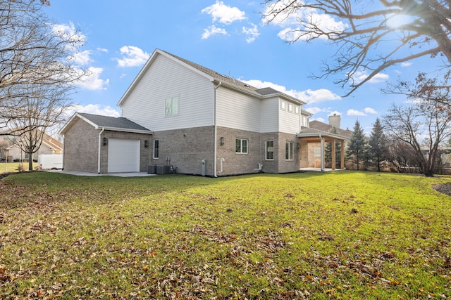 rear view of house with a yard and a garage