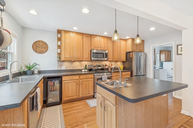 kitchen featuring wine cooler, appliances with stainless steel finishes, sink, and a center island with sink