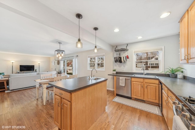 kitchen with sink, light wood-type flooring, stainless steel appliances, and a kitchen island