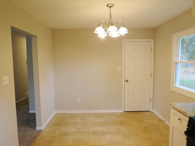 unfurnished dining area featuring a notable chandelier and light carpet