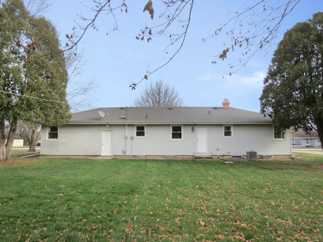 rear view of property featuring a yard and central AC unit