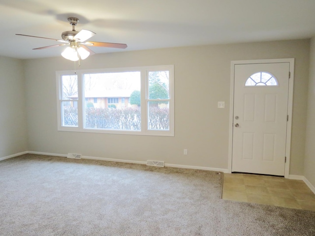 carpeted foyer featuring ceiling fan